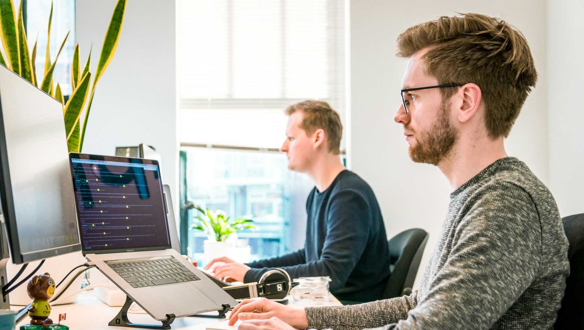 To menn sitter ved kontorpult